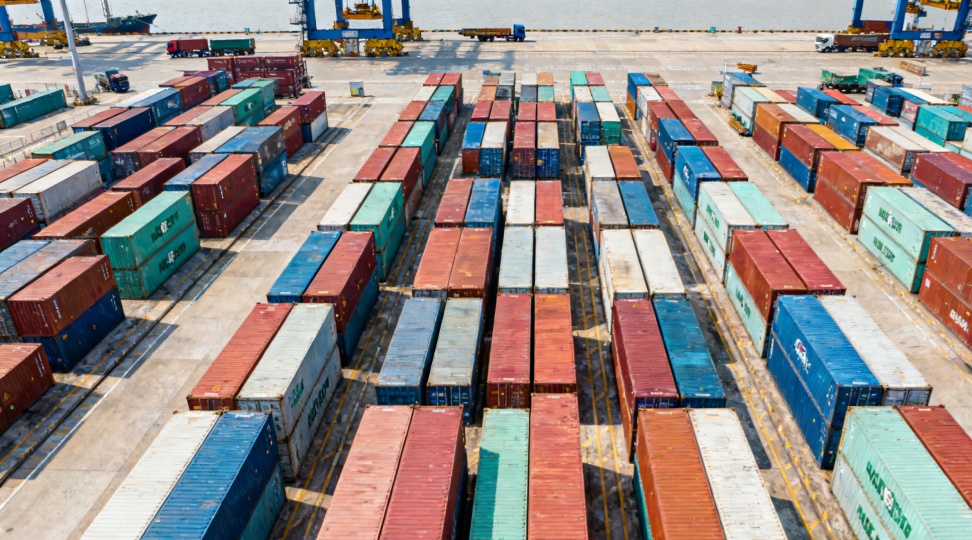 A top-down photo showing colorful containers and terminal activity at Ningbo-Zhoushan Port, representing cargo volume for ocean shipping from Ningbo to Hamburg.