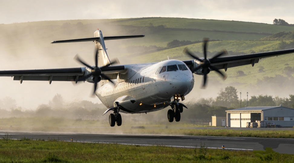 A turboprop freighter lifts off from a short runway surrounded by hills. These cargo planes carry 3 to 10 tonnes and serve airports with limited infrastructure across the Indonesian archipelago, Central Asia, and other remote Eurasian locations.